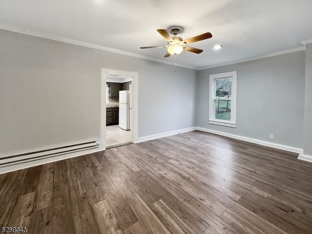 spare room featuring baseboards, ornamental molding, and wood finished floors