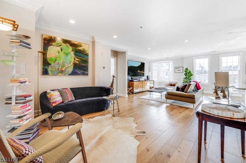 living area featuring light wood finished floors, baseboards, crown molding, and recessed lighting