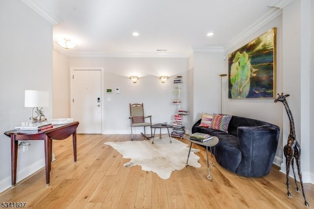 living area with ornamental molding, light wood-style flooring, and baseboards