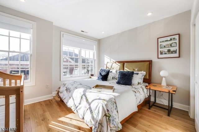 bedroom with visible vents, baseboards, and wood finished floors