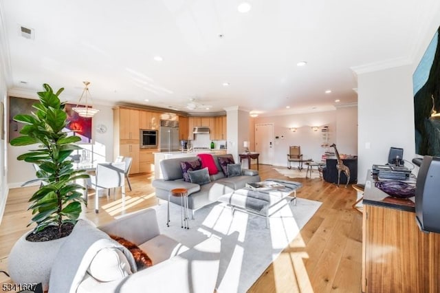 living room with crown molding, recessed lighting, visible vents, and light wood-style floors