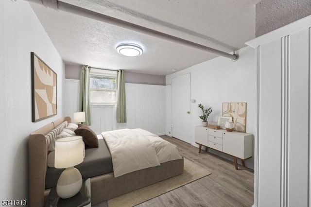 bedroom featuring a textured ceiling and wood finished floors