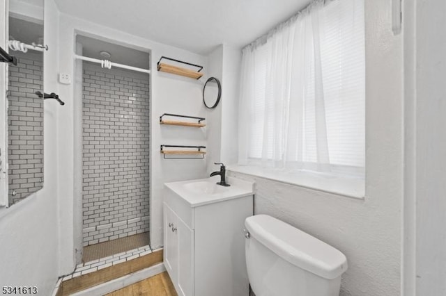 full bathroom with toilet, a stall shower, wood finished floors, and vanity