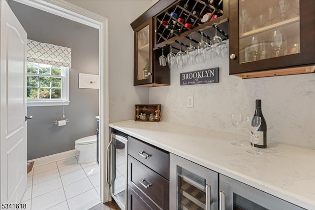 bar featuring a dry bar, light tile patterned floors, and beverage cooler