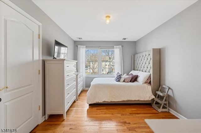 bedroom with light wood-type flooring and baseboards