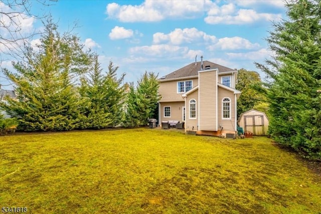 back of house with an outbuilding, a storage unit, and a lawn