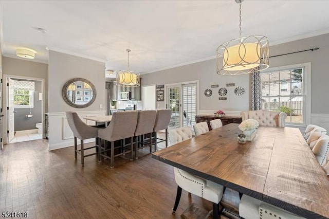 dining room with dark wood-style flooring and crown molding