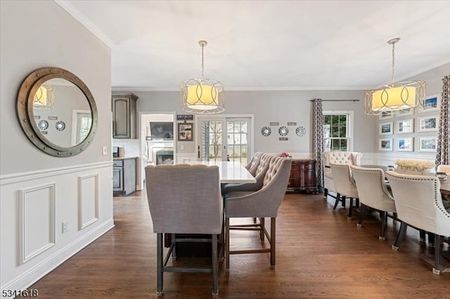 dining area featuring ornamental molding, dark wood-type flooring, and a wealth of natural light