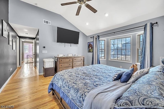 bedroom with ceiling fan, visible vents, baseboards, vaulted ceiling, and light wood-type flooring