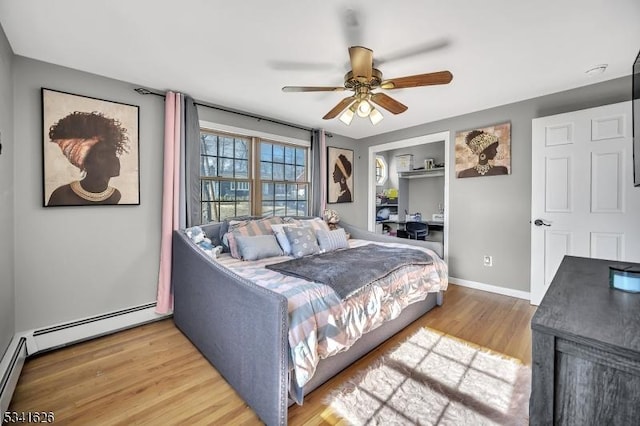 bedroom featuring a baseboard radiator, baseboards, ceiling fan, and wood finished floors