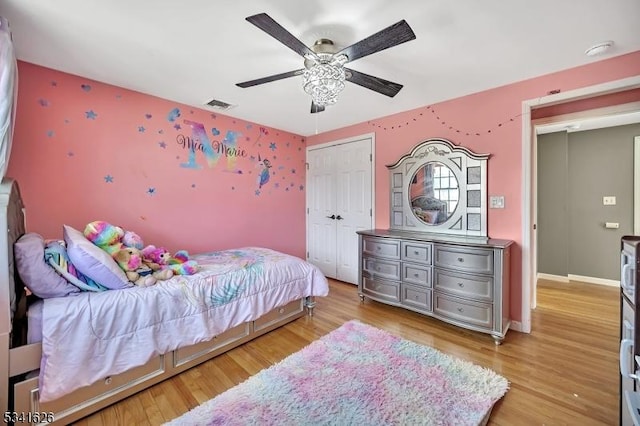 bedroom with a closet, visible vents, light wood-style floors, ceiling fan, and baseboards