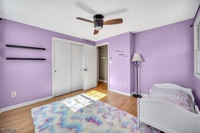 bedroom featuring a closet, ceiling fan, baseboards, and wood finished floors