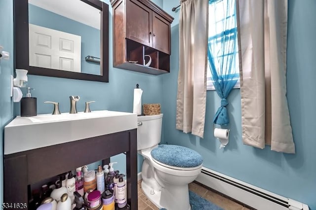 bathroom featuring tile patterned flooring, a baseboard radiator, vanity, and toilet