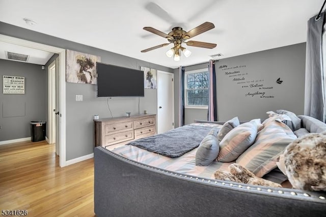 bedroom with light wood-type flooring, visible vents, baseboards, and a ceiling fan