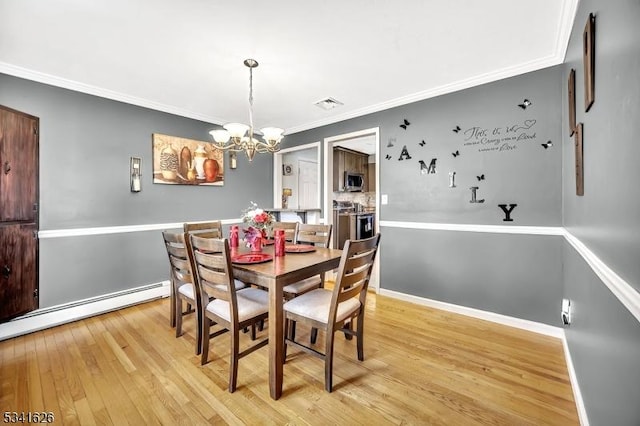 dining area featuring light wood finished floors, visible vents, ornamental molding, an inviting chandelier, and a baseboard heating unit