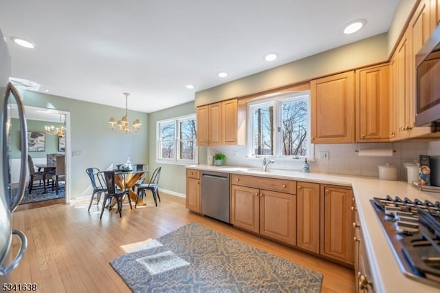 kitchen featuring stainless steel appliances, tasteful backsplash, and light wood-style flooring