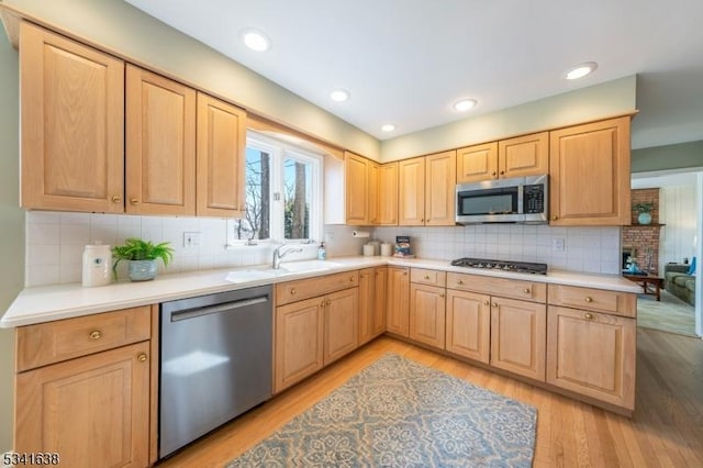 kitchen featuring a sink, appliances with stainless steel finishes, light brown cabinets, and light wood-style floors