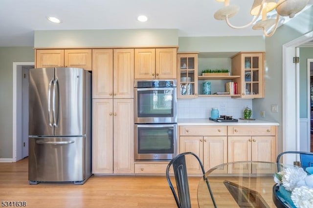 kitchen with light brown cabinetry, appliances with stainless steel finishes, light countertops, and light wood-style flooring