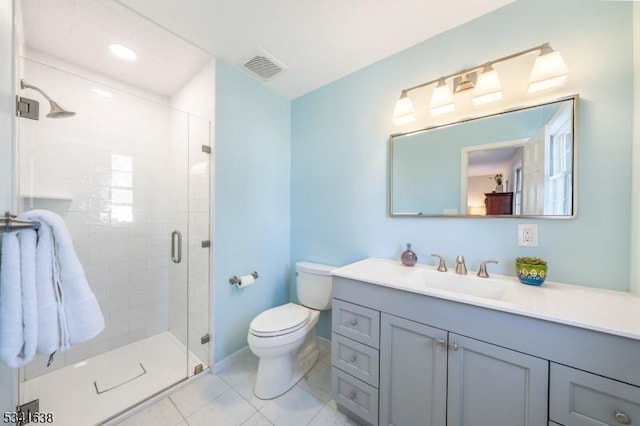 bathroom featuring visible vents, toilet, a shower stall, vanity, and baseboards