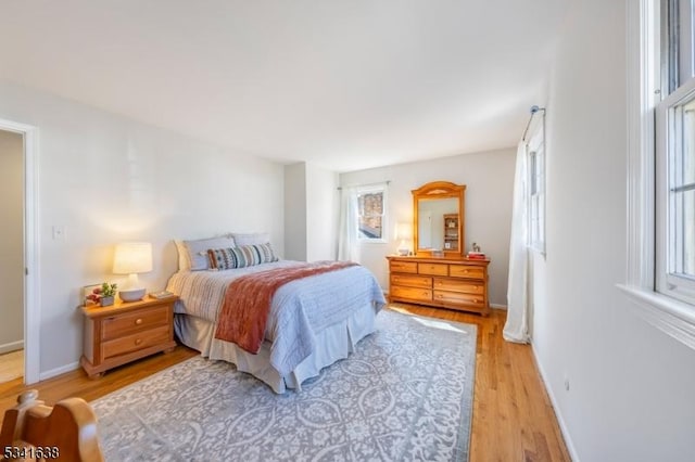 bedroom with light wood-type flooring and baseboards