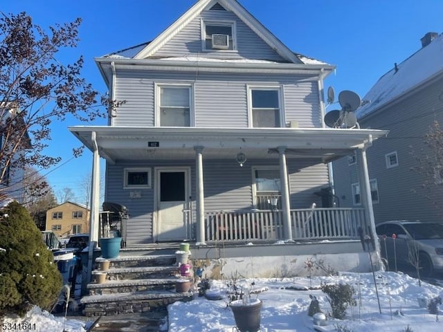 american foursquare style home with a porch and cooling unit