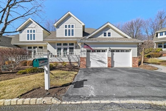 view of front of home featuring a garage, driveway, and brick siding