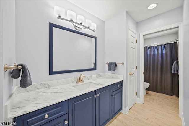 full bath with vanity, toilet, and wood finished floors