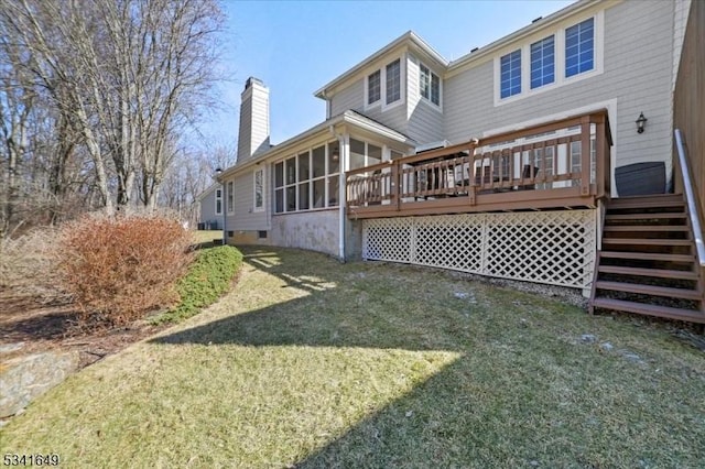 back of property featuring a yard, a chimney, a sunroom, crawl space, and a deck