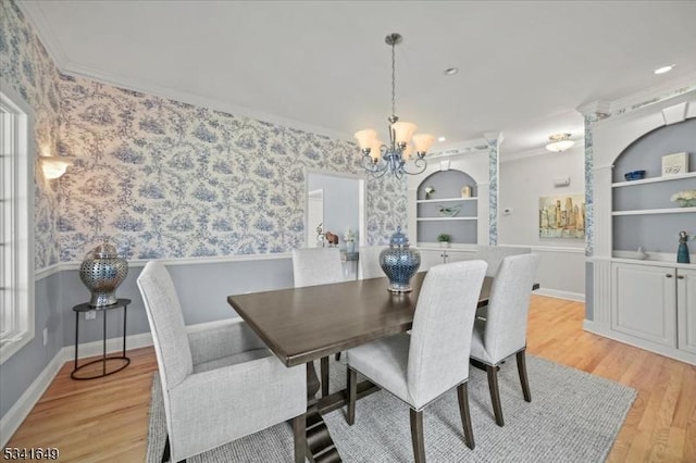 dining area with light wood-type flooring, wallpapered walls, built in shelves, and ornamental molding