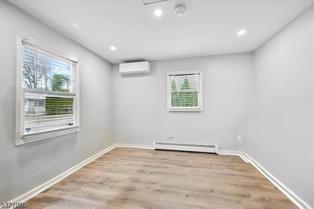 unfurnished room featuring baseboards, a wall unit AC, a baseboard radiator, wood finished floors, and recessed lighting