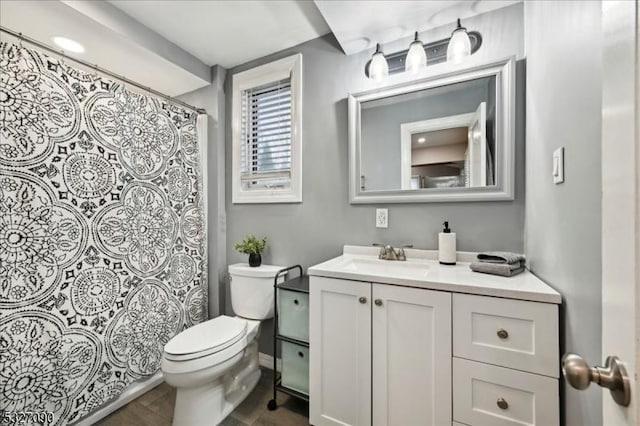 bathroom featuring curtained shower, vanity, and toilet