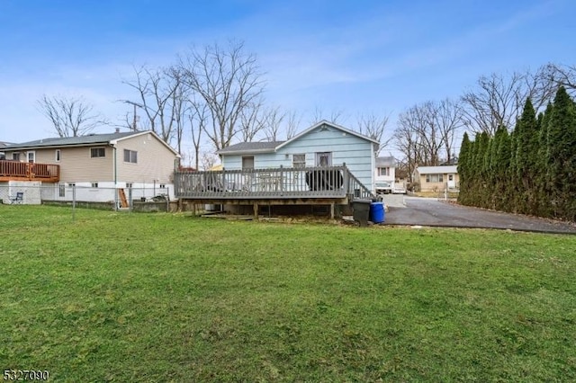 back of property featuring a lawn and a wooden deck