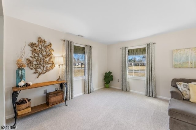 sitting room with visible vents, baseboards, and light colored carpet