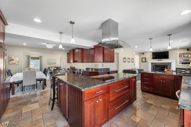 kitchen with black electric stovetop, stone tile floors, a kitchen island, dark brown cabinets, and island exhaust hood