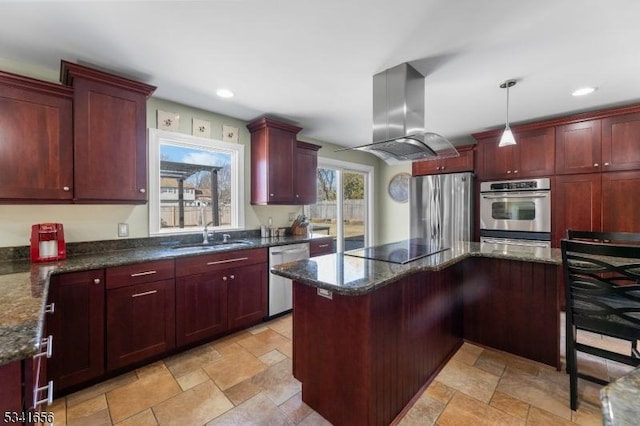 kitchen featuring island exhaust hood, stainless steel appliances, stone tile flooring, dark brown cabinets, and a sink