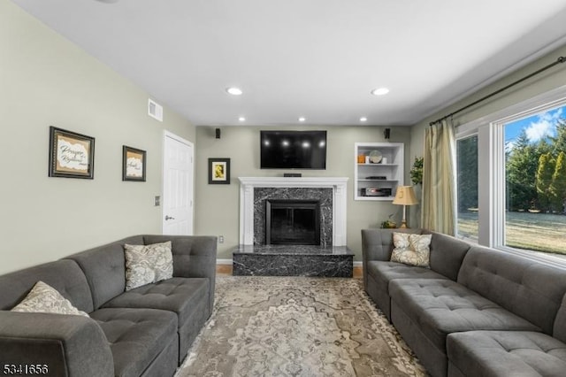 living area with recessed lighting, visible vents, and a high end fireplace