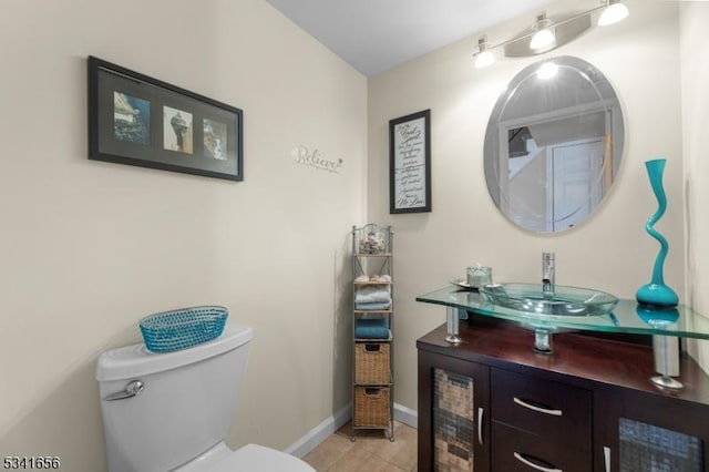 bathroom featuring toilet, tile patterned flooring, baseboards, and vanity