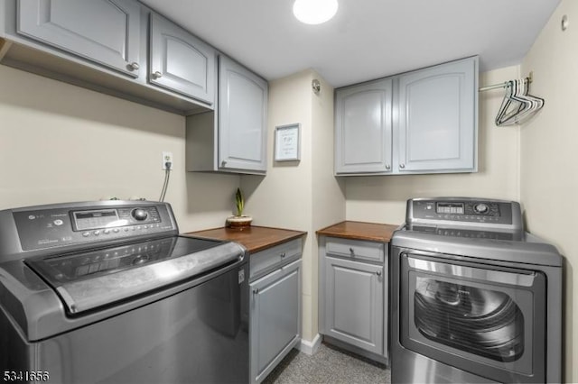 washroom with cabinet space and washer and clothes dryer