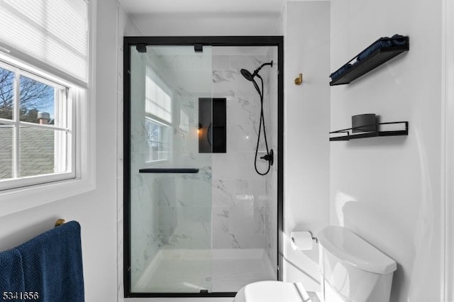 full bathroom with a marble finish shower and toilet