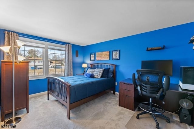 bedroom featuring light carpet and baseboards