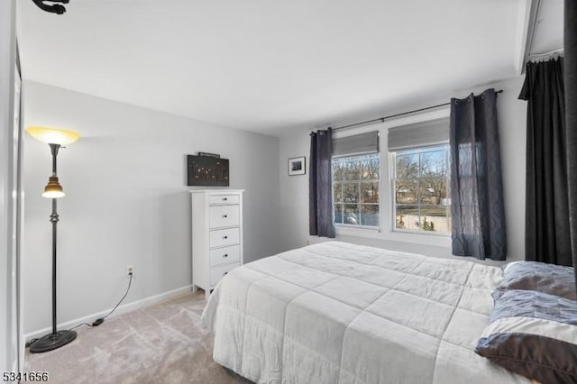 bedroom featuring light colored carpet and baseboards