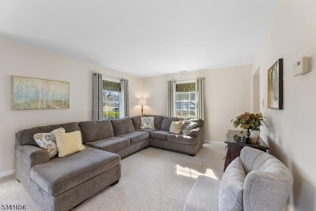 living area with light colored carpet and baseboards