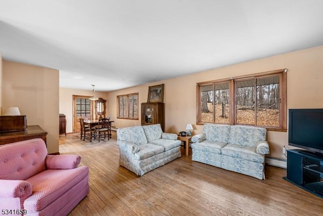 living room featuring a baseboard heating unit and light wood-style floors