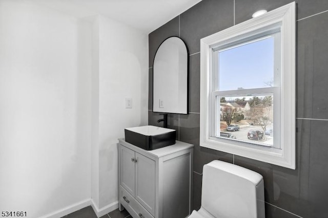 bathroom with toilet, baseboards, and vanity