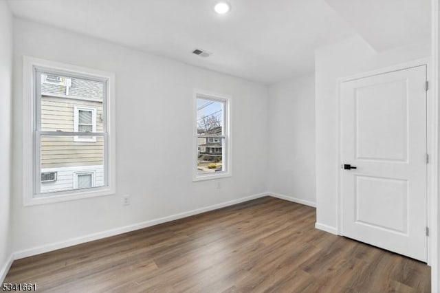 unfurnished room with visible vents, baseboards, and wood finished floors