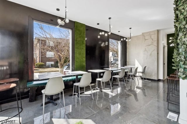 dining room featuring marble finish floor and a notable chandelier