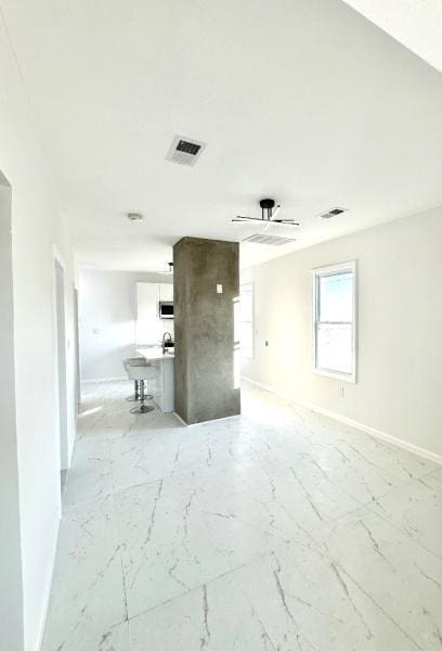 spare room featuring marble finish floor, baseboards, and visible vents