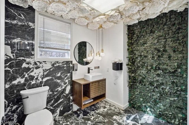 bathroom featuring baseboards, vanity, and toilet