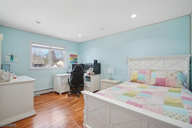 bedroom featuring light wood-style floors, a baseboard heating unit, and recessed lighting