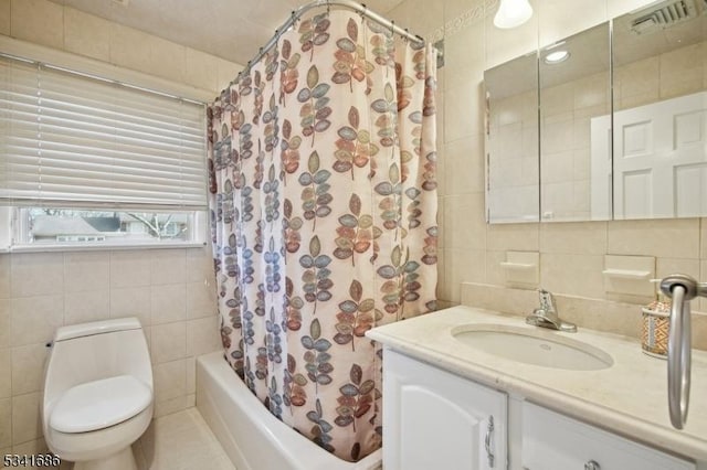 full bathroom featuring toilet, shower / tub combo, visible vents, vanity, and tile walls